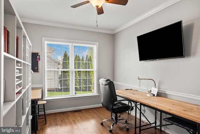 office space with visible vents, ceiling fan, baseboards, ornamental molding, and wood finished floors