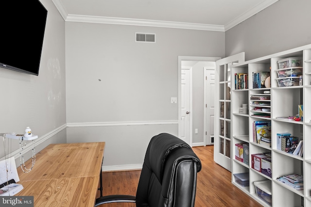office area featuring ornamental molding, visible vents, wood finished floors, and baseboards