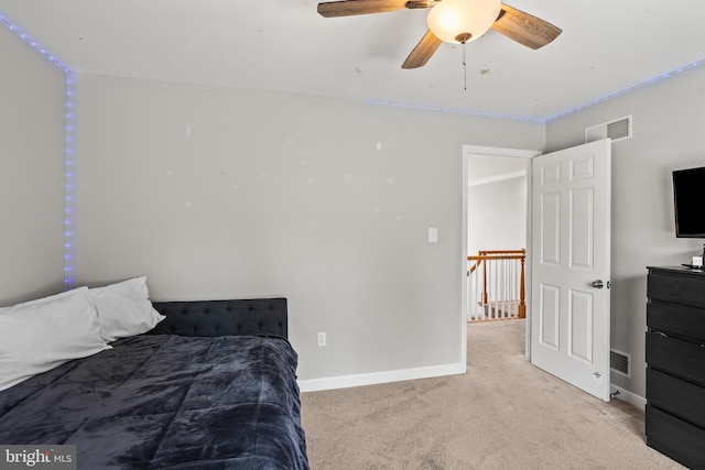 bedroom with a ceiling fan, visible vents, light carpet, and baseboards