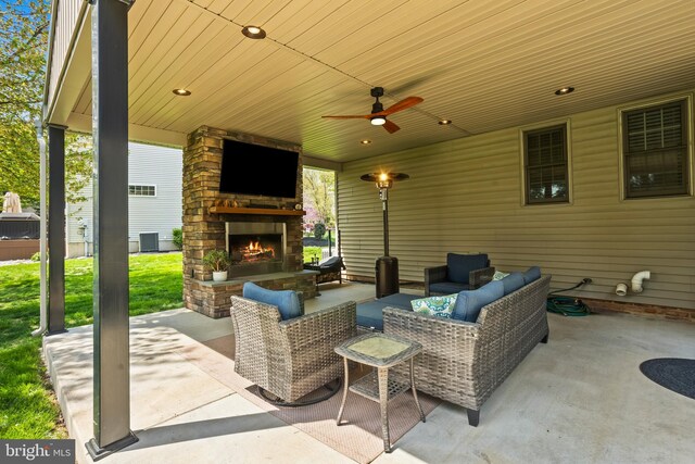 view of patio / terrace featuring an outdoor living space with a fireplace, a ceiling fan, and central air condition unit