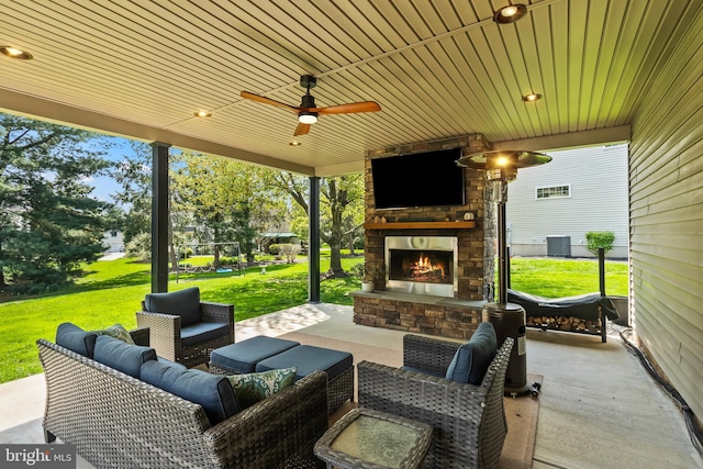 view of patio / terrace with a ceiling fan, central AC, and an outdoor living space with a fireplace