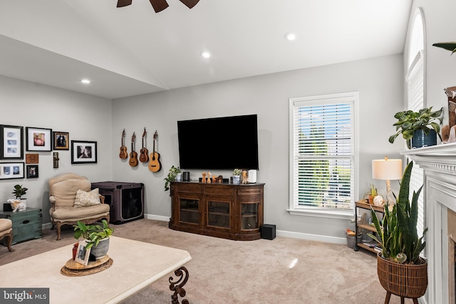 carpeted living room with recessed lighting, baseboards, a ceiling fan, a fireplace with flush hearth, and lofted ceiling