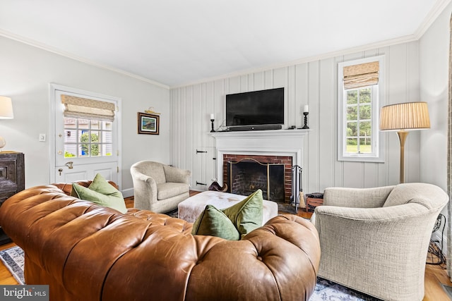 living room featuring ornamental molding, healthy amount of natural light, wood finished floors, and a fireplace