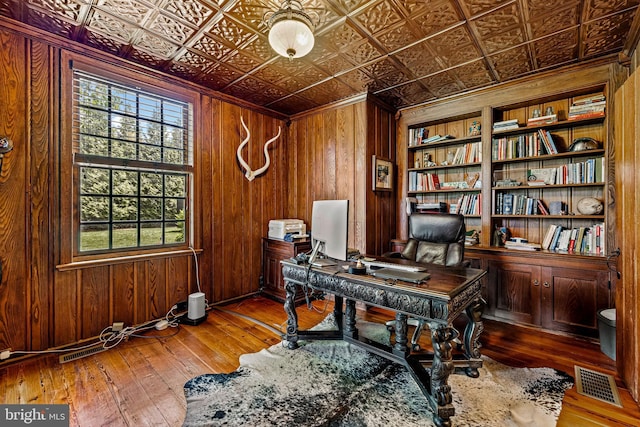office with wood-type flooring, an ornate ceiling, and wood walls