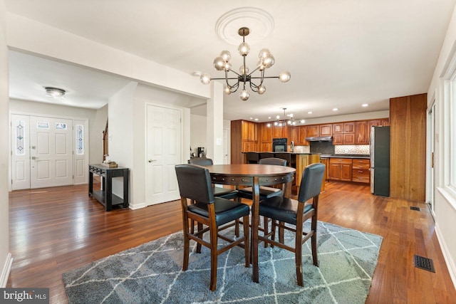 dining space featuring dark wood-style floors, visible vents, a notable chandelier, and recessed lighting