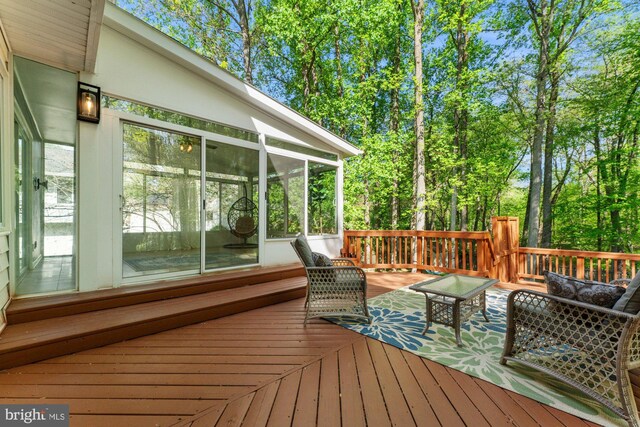 wooden deck with outdoor lounge area and a sunroom