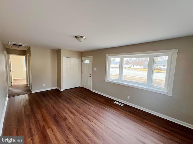 foyer featuring dark wood-type flooring, visible vents, and baseboards