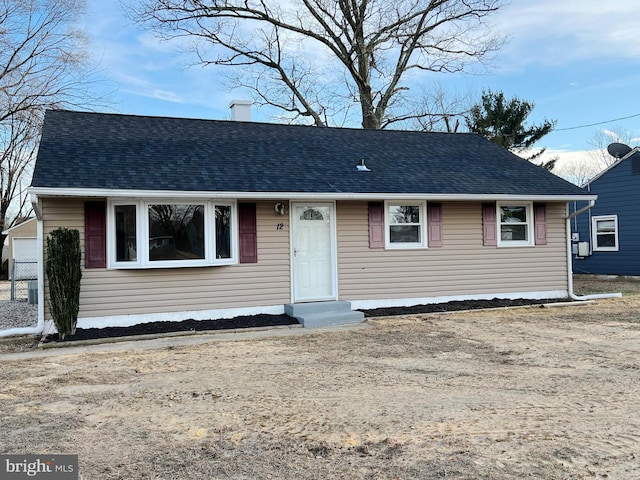 view of front of house featuring a chimney and roof with shingles