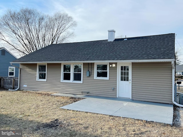 back of house with roof with shingles, a patio, and fence