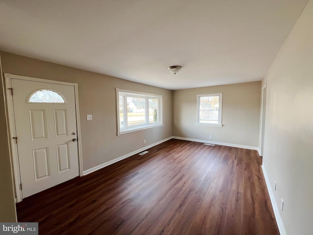 foyer featuring baseboards, visible vents, and dark wood-style floors