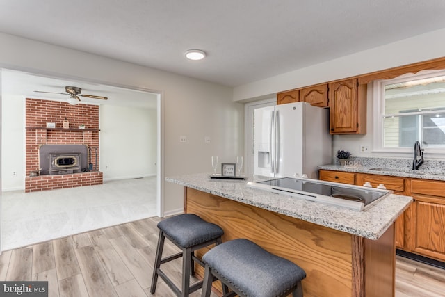 275 Wood Rise Ln, Winchester, VA 22602 - kitchen featuring light wood-style floors, a sink, black electric stovetop, and white fridge with ice dispenser