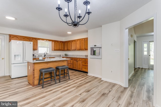 275 Wood Rise Ln, Winchester, VA 22602 - kitchen featuring brown cabinetry, a kitchen island, white appliances, light wood-style flooring, and a notable chandelier