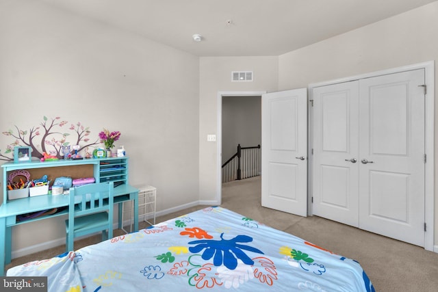 carpeted bedroom featuring visible vents, baseboards, and a closet