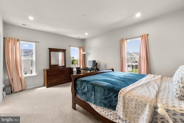 carpeted bedroom with baseboards, multiple windows, recessed lighting, and visible vents