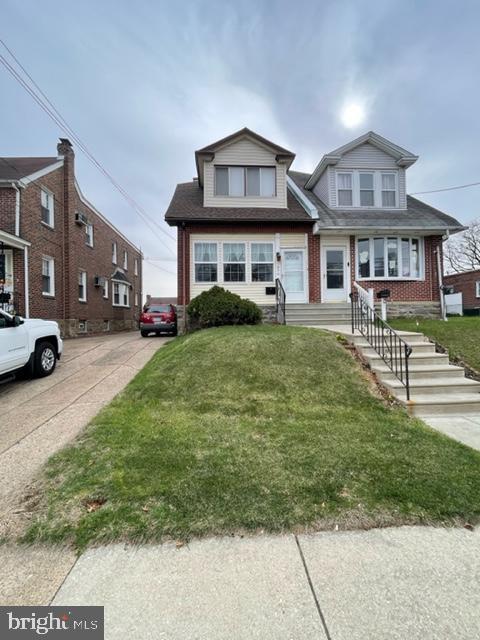 view of front of property featuring a front yard and brick siding