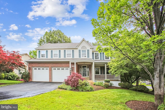 21130 Haystack Ct, Ashburn, VA 20147 - view of front of house featuring driveway, covered porch, an attached garage, a front lawn, and brick siding