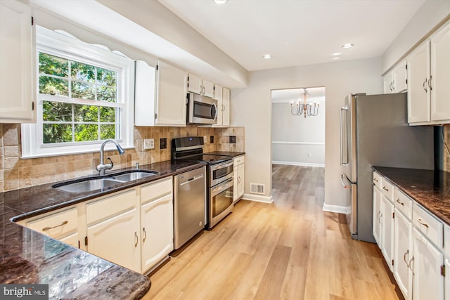 21130 Haystack Ct, Ashburn, VA 20147 - kitchen with stainless steel appliances, a sink, light wood-type flooring, a chandelier, and decorative backsplash