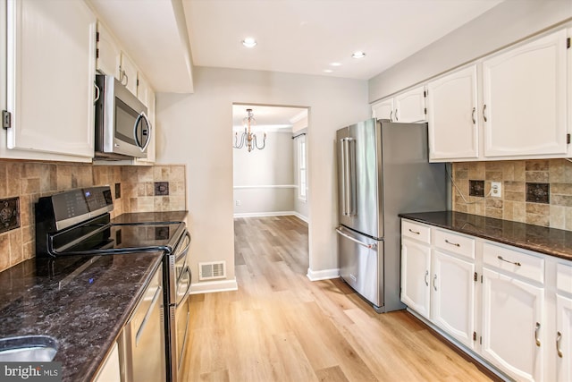 21130 Haystack Ct, Ashburn, VA 20147 - kitchen featuring appliances with stainless steel finishes, white cabinets, light wood-type flooring, baseboards, and dark stone countertops