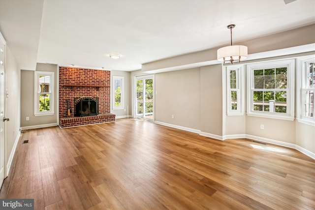21130 Haystack Ct, Ashburn, VA 20147 - unfurnished living room featuring baseboards, light wood-style floors, and a fireplace