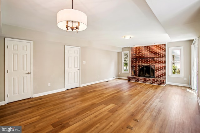 21130 Haystack Ct, Ashburn, VA 20147 - unfurnished living room featuring light wood finished floors, baseboards, and a brick fireplace