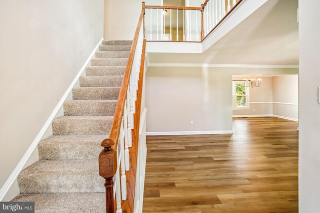 21130 Haystack Ct, Ashburn, VA 20147 - staircase featuring a chandelier, wood finished floors, a high ceiling, baseboards, and crown molding