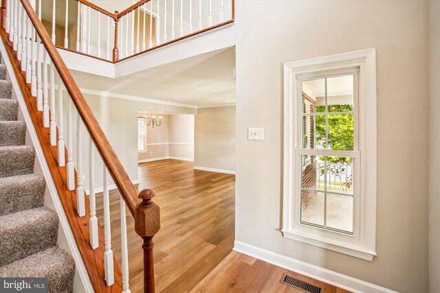 21130 Haystack Ct, Ashburn, VA 20147 - stairway with a chandelier, baseboards, wood finished floors, crown molding, and a high ceiling
