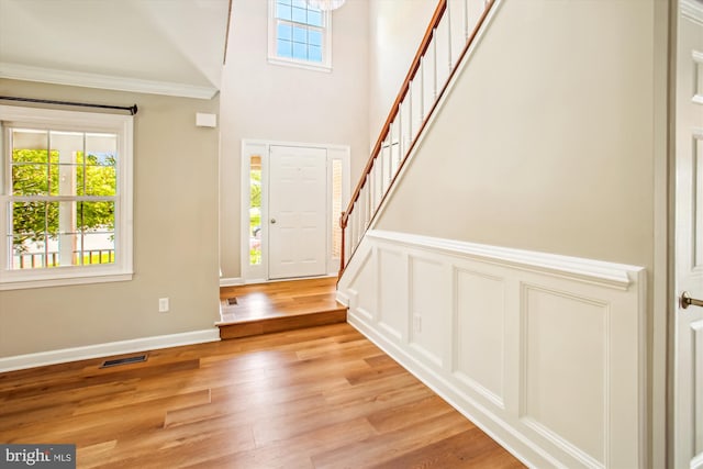 21130 Haystack Ct, Ashburn, VA 20147 - foyer entrance with healthy amount of natural light, stairs, light wood-style floors, crown molding, and a towering ceiling