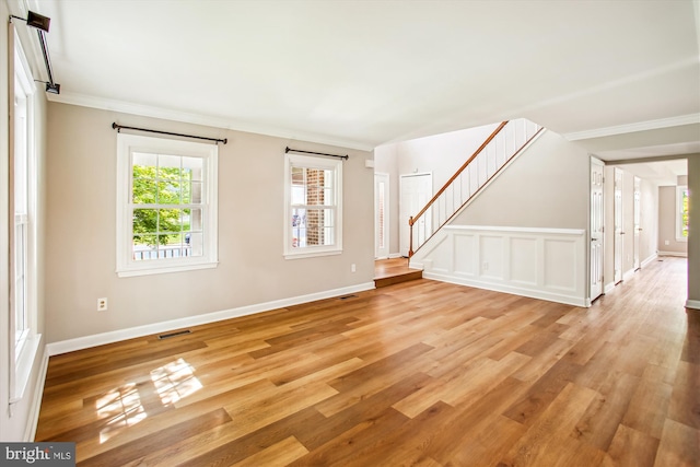 21130 Haystack Ct, Ashburn, VA 20147 - unfurnished living room with ornamental molding, light wood finished floors, stairs, healthy amount of natural light, and baseboards
