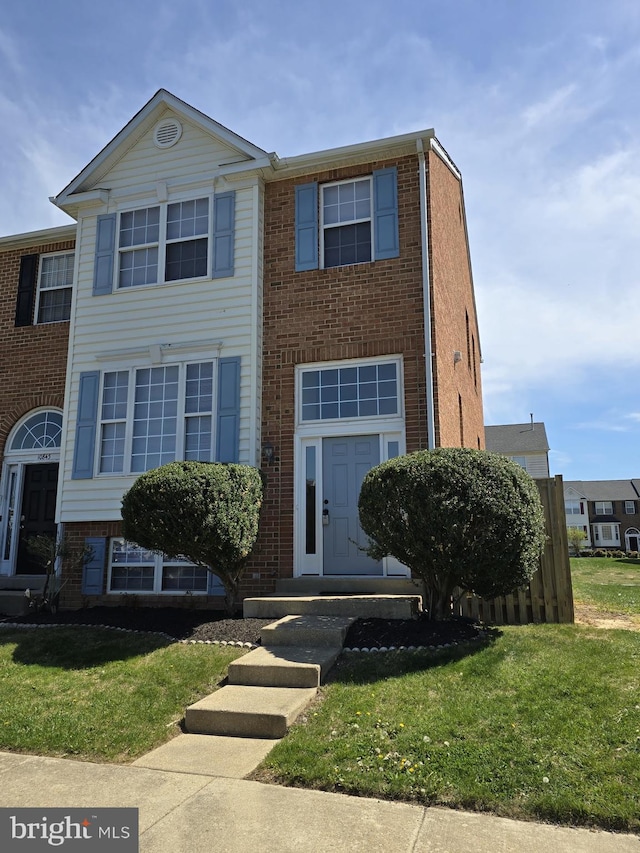 view of property with brick siding and a front yard