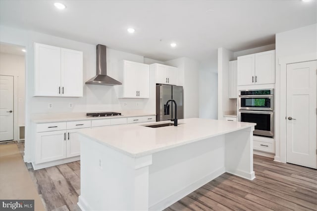 9842 Fire Tower Rd, Ijamsville, MD 21754 - kitchen with wall chimney exhaust hood, a sink, appliances with stainless steel finishes, light wood-style flooring, and light countertops