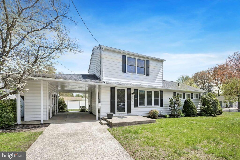 18 Oak Landing Rd, Lumberton, NJ 08048 - traditional-style home with driveway, a front yard, roof with shingles, and an attached carport