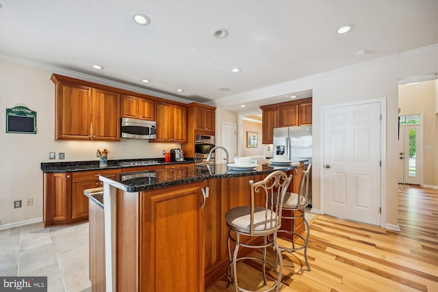502 Leaning Oak St, Gaithersburg, MD 20878 - kitchen featuring stainless steel appliances, brown cabinets, ornamental molding, a center island with sink, and a breakfast bar area