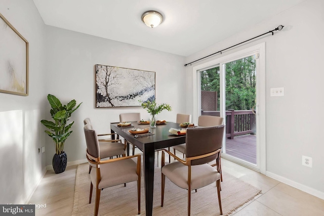 dining space featuring baseboards and light tile patterned floors