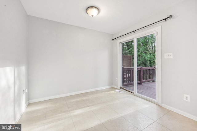 unfurnished room featuring light tile patterned floors and baseboards