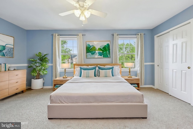 carpeted bedroom with baseboards, ceiling fan, multiple windows, and a closet