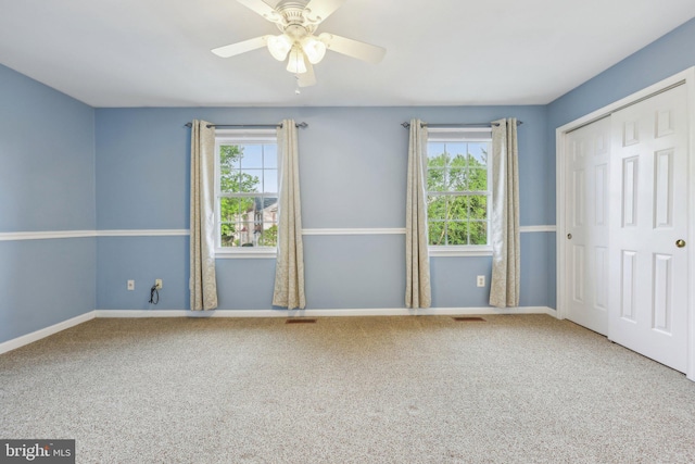 unfurnished bedroom featuring baseboards, carpet floors, and multiple windows