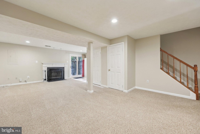 unfurnished living room with a fireplace with flush hearth, recessed lighting, carpet flooring, and baseboards