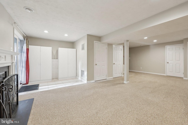 unfurnished living room with baseboards, visible vents, carpet flooring, and recessed lighting