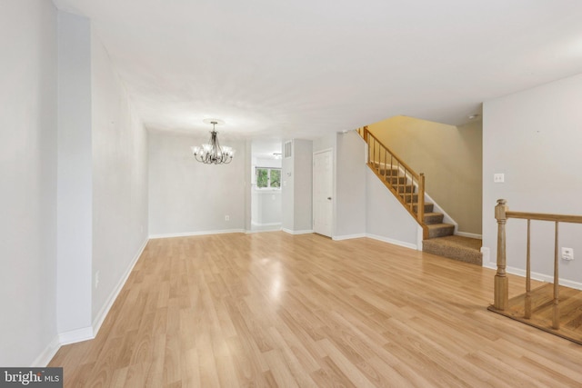 interior space featuring baseboards, stairway, a notable chandelier, and light wood finished floors