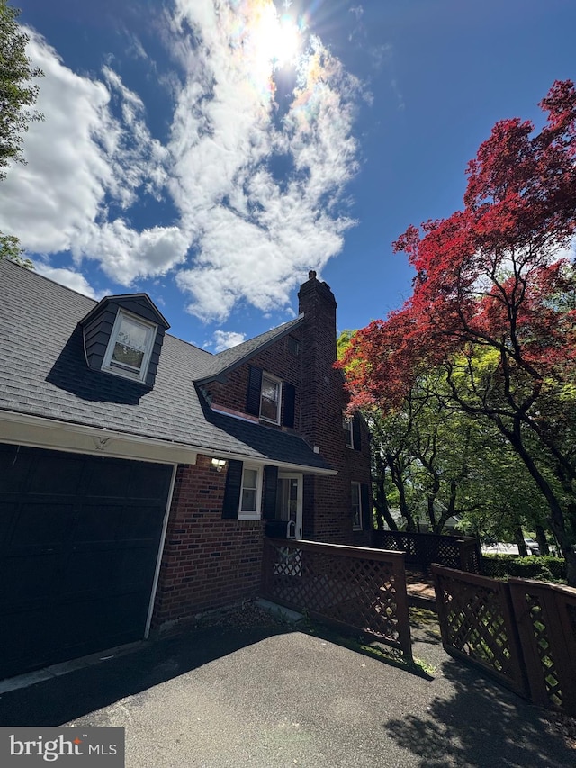 7915 New Second St, Elkins Park, PA 19027 - view of front of house featuring brick siding, a chimney, an attached garage, and a shingled roof
