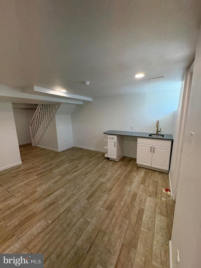 7915 New Second St, Elkins Park, PA 19027 - basement featuring a sink, light wood-style flooring, and baseboards