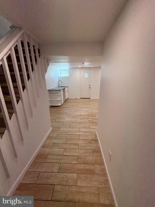 7915 New Second St, Elkins Park, PA 19027 - hallway featuring stairs, light wood-type flooring, a sink, and baseboards