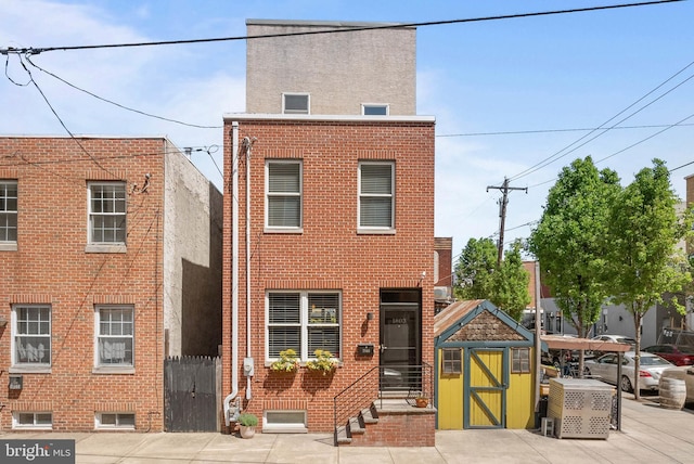 view of front of house with a shed and brick siding