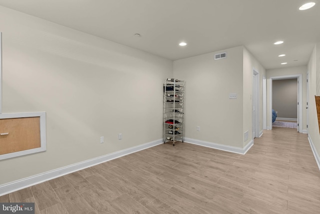 spare room featuring light wood-style floors, visible vents, recessed lighting, and baseboards