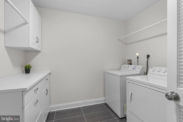 laundry area with dark tile patterned floors, washer and dryer, cabinet space, and baseboards