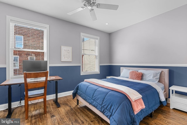 bedroom featuring baseboards, wood finished floors, and a ceiling fan