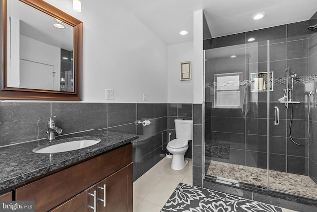 full bath featuring toilet, a stall shower, tile walls, and tile patterned floors