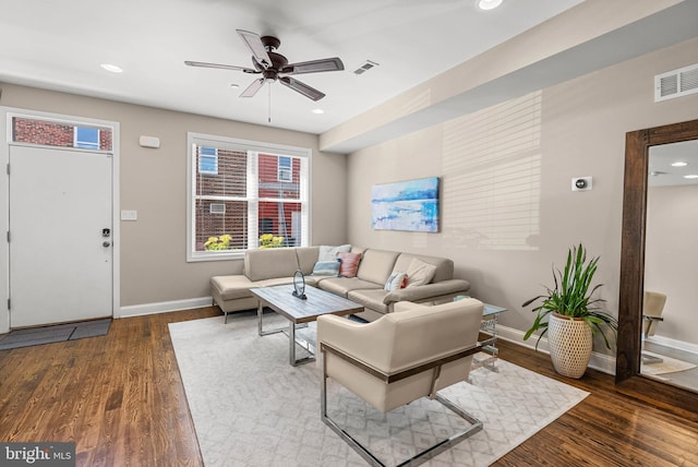 living area featuring visible vents, ceiling fan, wood finished floors, and baseboards