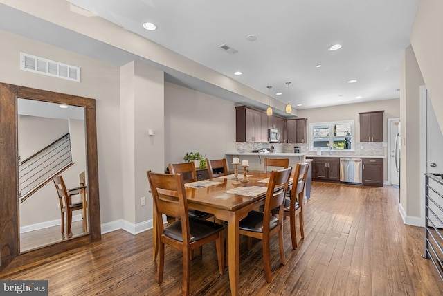 dining room featuring dark wood-style floors, visible vents, baseboards, and recessed lighting