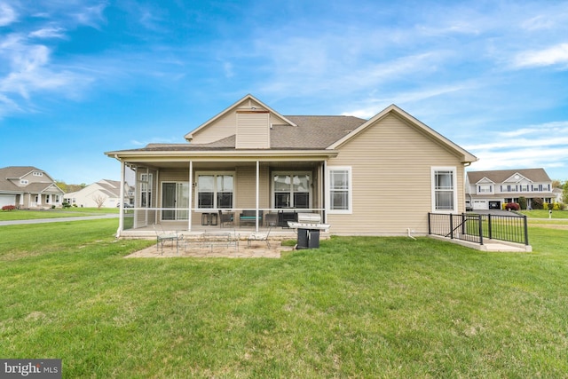back of property featuring a lawn, a patio, and roof with shingles